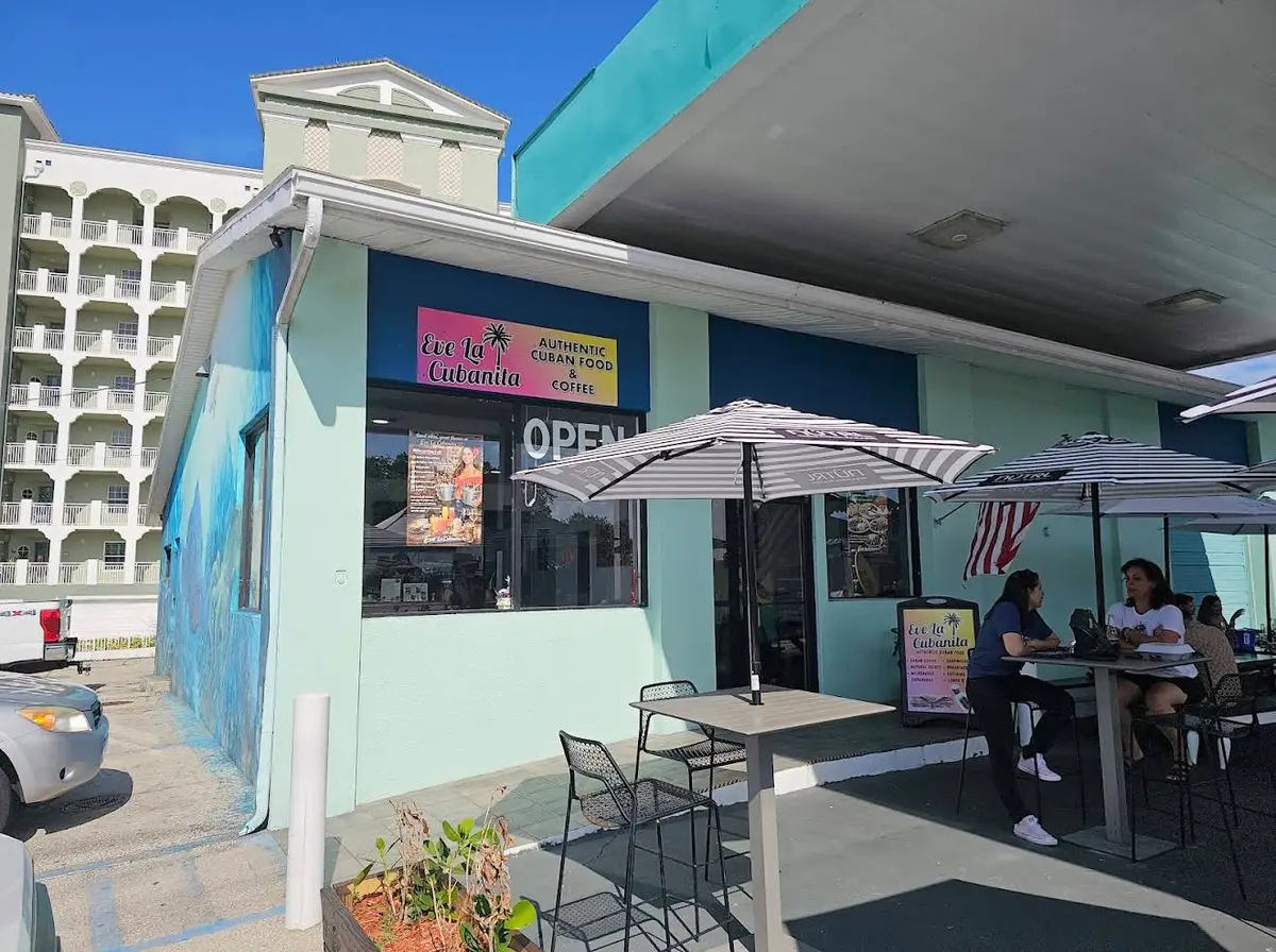 The mint-blue café exterior with striped umbrellas